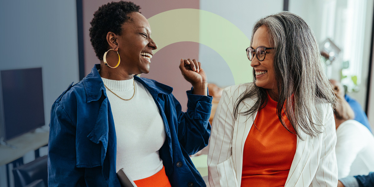 Two women talking and laughing in an office